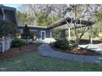 Charming home featuring a covered carport, inviting entrance and beautiful gravel path leading to the front door at 1115 Valley Park Dr, Chapel Hill, NC 27514