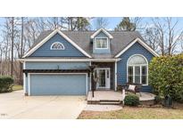 Charming blue two-story home with a neatly kept lawn and inviting front porch at 1217 Hillingdon Way, Raleigh, NC 27614