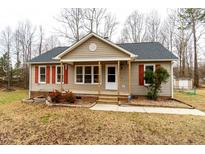 Charming ranch-style home featuring tan siding, red shutters, and a welcoming front porch at 12491 Buffalo Rd, Archer Lodge, NC 27527
