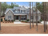 Charming stone and gray two-story home with inviting front porch and landscaped front yard at 170 Pine Cone Loop, Pittsboro, NC 27312