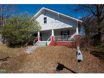 Charming two-story home with white siding, red foundation, and landscaped front yard and mailbox at 1805 Shelton Ave, Durham, NC 27707