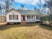 Charming single-story home featuring a welcoming front porch and a red front door, exuding warmth and curb appeal at 20 Beechnut Ct, Franklinton, NC 27525