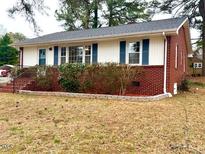 Charming single-story home featuring a brick facade, and front yard landscaping at 201 W Thorndale Dr, Oxford, NC 27565