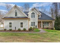 Charming two-story home with stone accents, manicured landscaping, and a welcoming front porch at 2100 Troys Trl, Franklinton, NC 27525