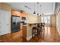 Bright kitchen features stainless steel appliances, granite countertops, and a breakfast bar with seating at 300 Finsbury St # 313, Durham, NC 27703