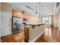 Modern kitchen features stainless steel appliances, granite countertops, and an island with pendant lighting at 300 Finsbury St # 313, Durham, NC 27703