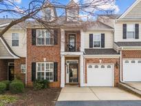 Charming brick townhouse with a one-car garage, small balcony, and meticulously maintained landscaping at 3124 Elm Tree Ln, Raleigh, NC 27614