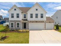 Beautiful two-story home featuring a three-car garage, stone accents, and well-maintained landscaping at 350 Arlie Ln, Lillington, NC 27546