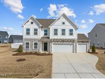 Beautiful two-story home with stone accents and a three-car garage at 350 Arlie Ln, Lillington, NC 27546