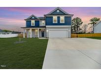 Charming two-story home with blue and gray accents, well-manicured lawn, and a two-car garage at 430 St. Claire Dr, Fuquay Varina, NC 27526