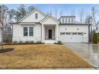 Charming white two-story home featuring a covered porch and attached two-car garage at 616 Long Lake Dr, Fuquay Varina, NC 27526