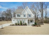 Charming two-story home featuring a covered porch and beautifully landscaped front yard at 76 Freewill Pl, Raleigh, NC 27603