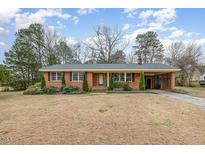 Charming brick home featuring a well-manicured lawn and mature landscaping at 78 Eagle Rd, Coats, NC 27521