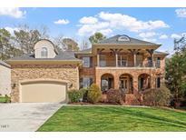 Charming two-story brick home featuring a manicured lawn and a welcoming front porch at 8912 Riverview Park Dr, Raleigh, NC 27613