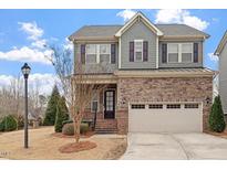 Charming two-story home with a combination brick and gray shingle exterior, plus a two-car garage at 921 Regency Cottage Pl, Cary, NC 27518