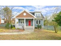 Charming home featuring a red front door, blue siding, and a cozy, covered front porch at 100 E Delafield Ave, Durham, NC 27704