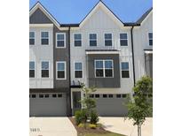 Charming townhome featuring a modern gray and white facade with attached garages and well-maintained landscaping at 1005 Regalia Rd # 32, Durham, NC 27713