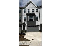 Modern townhome featuring a two-car garage and neutral-tone exterior with black trim and visible house number at 1005 Regalia Rd # 32, Durham, NC 27713