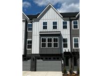 Modern townhome exterior with gray siding, attached garages, and neatly trimmed landscaping at 1011 Regalia Rd # 29, Durham, NC 27713