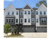 Modern townhome showcasing a three-story facade, gray and white siding, and individual garages at 1013 Regalia Rd # 28, Durham, NC 27713