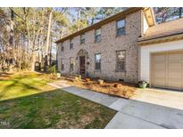 Charming two-story brick home featuring a well-manicured lawn, and attached garage at 1201 Deerfield Dr, Cary, NC 27511