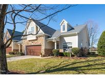 Charming home boasts stone accents, a well-manicured lawn, and an attached two-car garage at 126 Star Flower Ct, Apex, NC 27539