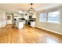 Spacious kitchen with white cabinets, stainless steel appliances, granite counters and hardwood floors at 128 Barclay Rd, Durham, NC 27712