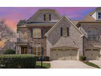 Beautiful two-story home with brick and stone facade, an attached two-car garage, and a manicured front yard at 164 Arabella Ct, Cary, NC 27518