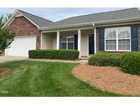 Charming single-story home with brick accents, manicured lawn, and inviting front porch at 1906 Hawfields Crossing Ln, Mebane, NC 27302