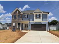 Two-story home featuring blue siding, brick accents, a two-car garage, and a well-manicured lawn at 2102 Channel St, Graham, NC 27253