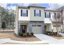 Charming two-story townhome with stone accents, a one-car garage, and a well-manicured lawn at 2201 Sweet Annie Way, Wake Forest, NC 27587