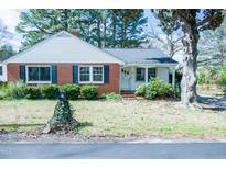 Charming red brick home with white trim, shutters, and landscaped front yard at 229 Short St, Wendell, NC 27591