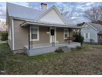 Charming single-Gathering home with a covered front porch and swing, steps, and manicured lawn at 301 Wilson St, Franklinton, NC 27525