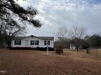 Cozy home featuring manicured landscaping, a charming birdhouse, and a spacious yard at 3211 Kipling Rd, Fuquay Varina, NC 27526