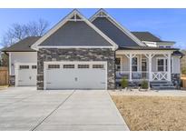 Charming home features a two-car garage and inviting front porch at 33 Song Breeze Cir, Angier, NC 27501