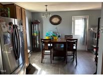 A dining room features wood-look flooring, wood table and chairs, and a stainless steel refrigerator at 402 Todd Hill Dr, Wendell, NC 27591