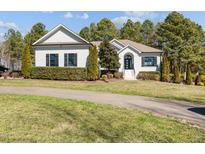 Charming white brick home with black shutters and lush landscaping providing beautiful curb appeal at 4050 Cannady Mill Rd, Kittrell, NC 27544