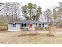Charming single-story home with gray siding, blue shutters, and a vibrant orange front door at 4814 Fayetteville Rd, Durham, NC 27713