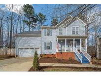 Charming two-story home with light blue siding, blue shutters, and a welcoming front porch with blue painted steps at 507 Town Crier Ct, Hillsborough, NC 27278