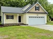 Charming, newly built home featuring yellow siding, a covered porch, and a two-car garage at 512 Hicksmill Rd, Oxford, NC 27565