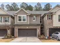 Charming townhome with a two-car garage and brick accents on the facade for added curb appeal at 521 Rockcastle Dr, Cary, NC 27519