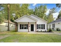 Charming single-story home with white siding, black shutters, and a well-maintained front yard at 5512 Hickory Ln, Raleigh, NC 27603