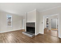 Bright living room with wood floors, fireplace and large window at 5738 Sentinel Dr, Raleigh, NC 27609