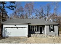 Charming single-story home featuring a gray exterior, attached garage, and stone accents near the entrance at 600 Hicksmill Rd, Oxford, NC 27565