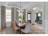 A beautiful dining room with hardwood floors and modern chandelier lighting features an inviting atmosphere at 72 Cultivator Ct, Angier, NC 27501