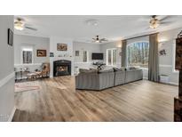 Spacious living room featuring a fireplace, large windows, and wood-look floors, providing a warm and inviting atmosphere at 7214 Southern Trl, Chapel Hill, NC 27516