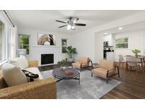 Bright living room features a fireplace, neutral walls, and wood-look floors that flow seamlessly into the dining area at 1006 Linwood Ave, Durham, NC 27701