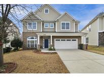 Charming two-story home featuring a brick and siding exterior, with a well-manicured front yard at 1112 Jewel Creek Dr, Cary, NC 27519