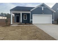 Charming single-story home with blue siding, a white garage door, and a covered entryway at 11186 Salers Loop, Middlesex, NC 27557