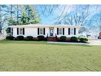 Charming one-story home with a well-manicured front lawn and classic white exterior with black trim at 117 Johnson St, Broadway, NC 27505